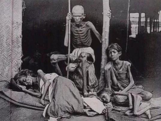 A man stands watch over his starving